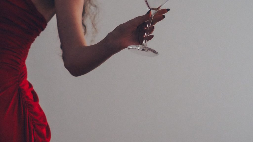 Femme élégante en robe rouge un verre à la main