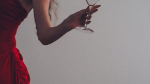 Femme élégante en robe rouge un verre à la main